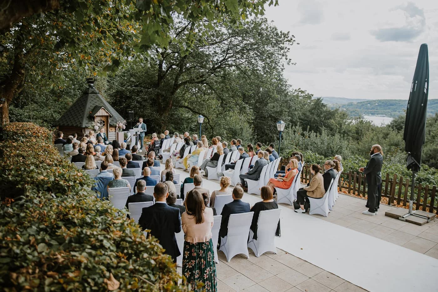 Brautpaar mit Hochzeitsgästen während der freien Trauung auf der Terrasse mit Blick auf den Baldeneysee
