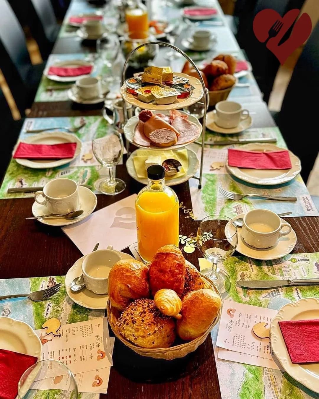 Eingedeckter Frühstückstisch mit frischem Orangensaft und Brötchen