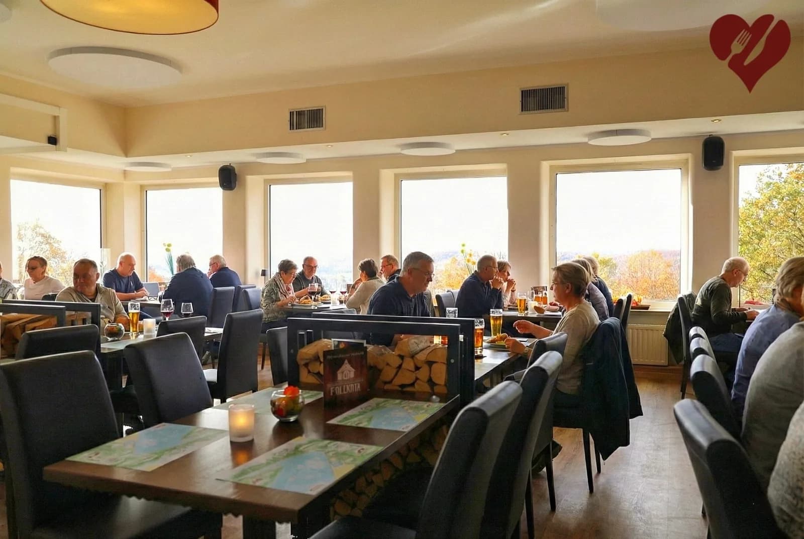 Blick in den Gastraum der Heimlichen Liebe mit essenden Gästen und Panoramablick
